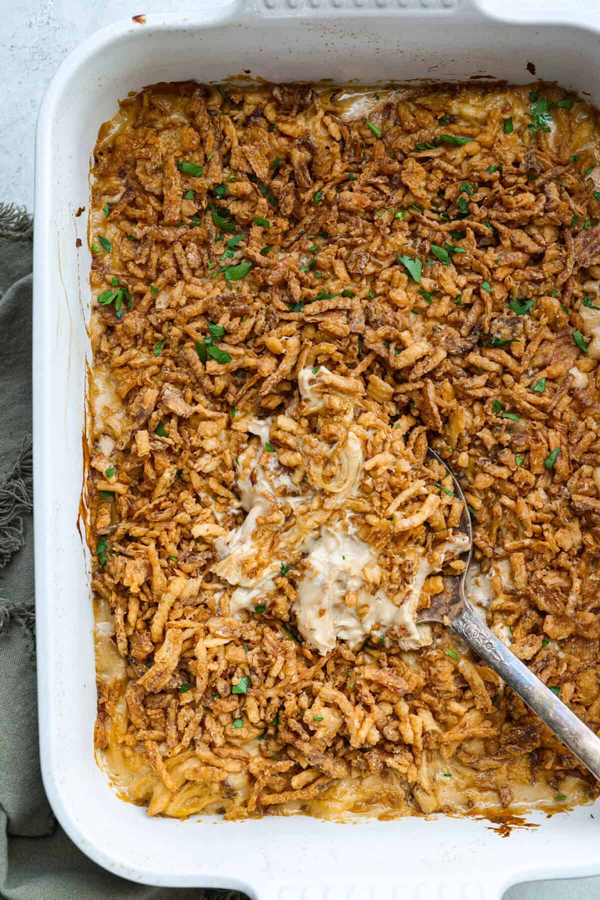 Creamy, cheesy, and packed with shredded chicken, this French onion chicken casserole is comfort food at its best! Inspired by French onion soup and dip, it’s topped with crispy fried onions for a crunchy finish. Overhead shot of baked French onion chicken casserole in a baking dish.