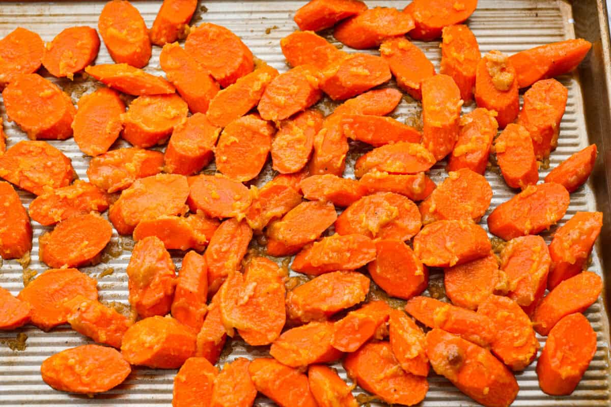 Brown Sugar glazed carrots are that sneaky-simple side that always gets rave reviews. The brown sugar caramelizes into the best buttery sweetness, and somehow everyone ends up going back for seconds. Glazed carrots spread out on a baking sheet.