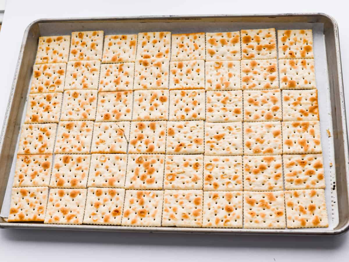If you want a quick, crunchy treat with a bit of holiday mischief, this Grinch Christmas Crack is it. Sweet, salty, and totally addictive. My classic Christmas Crack is always a hit, but this version brings all the Grinchy fun! Saltine crackers spread out on a cookie sheet.