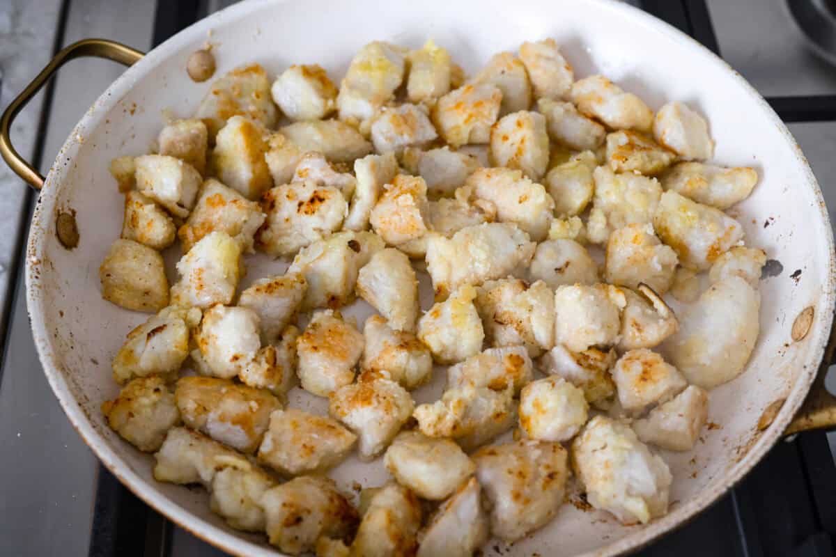 Sticky, sweet, and totally irresistible, this honey butter chicken brings golden brown perfection to your dinner table. One pan, picky-eater approved, and guaranteed to have everyone begging for seconds. Cornstarch covered chicken cooking in a skillet.