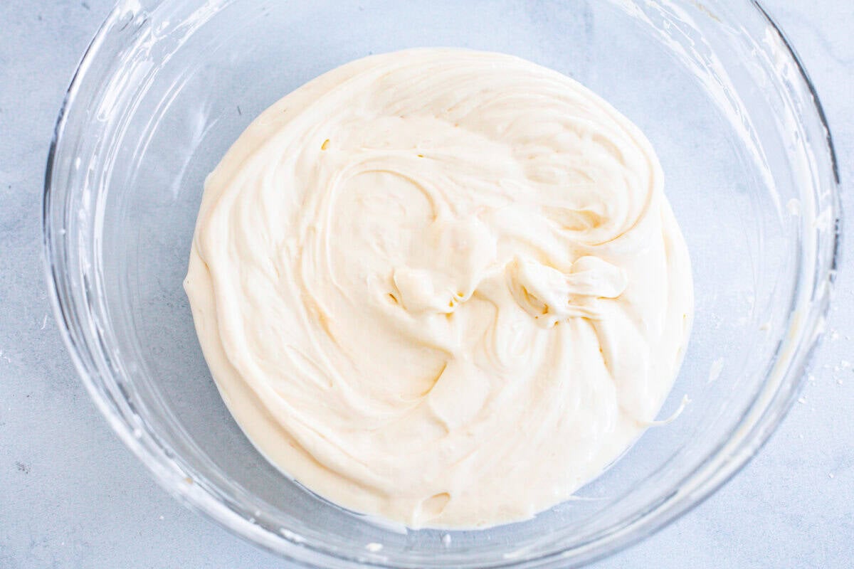 These Hostess Cupcake Cookies take your favorite childhood treat and turn it into soft, chocolate cookies! They are topped with sweet marshmallow and smooth chocolate ganache, and of course, the classic white swirl! Overhead shot of a bowl of melted white chocolate.