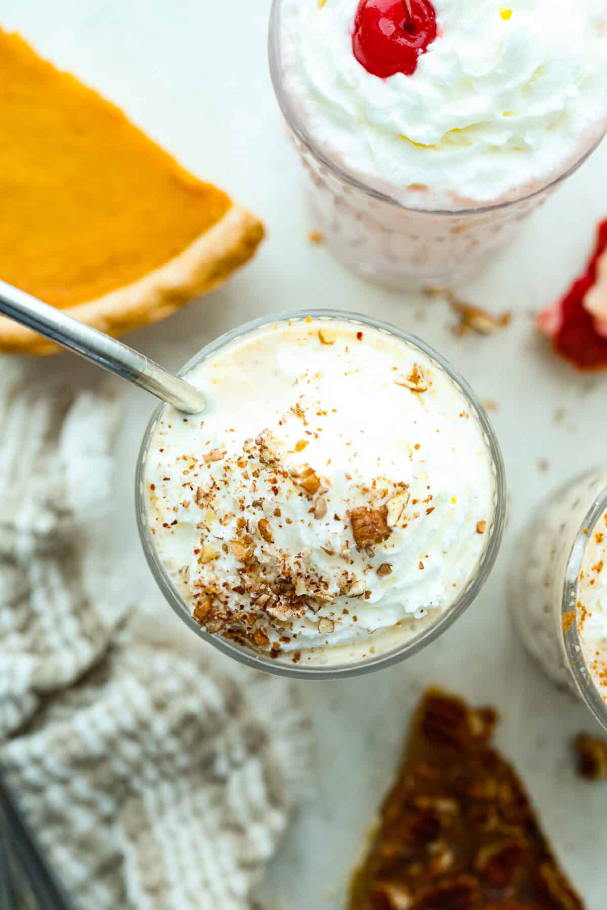 Leftover pie milkshakes are the sweetest way to give your extra pie new life! Just grab a slice, blend it with creamy ice cream, and sip your way to dessert bliss. Top down picture of pie milkshakes garnished with whipped cream and nuts.