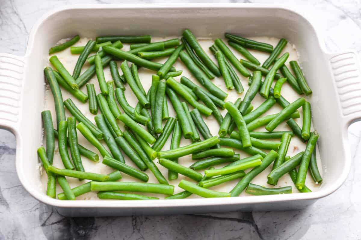 This Thanksgiving leftover casserole is the best way to enjoy every last bit of your holiday meal. I give you tips for keeping it moist, flavorful, and perfectly layered. Green beans sprinkled on top of the mashed potatoes.