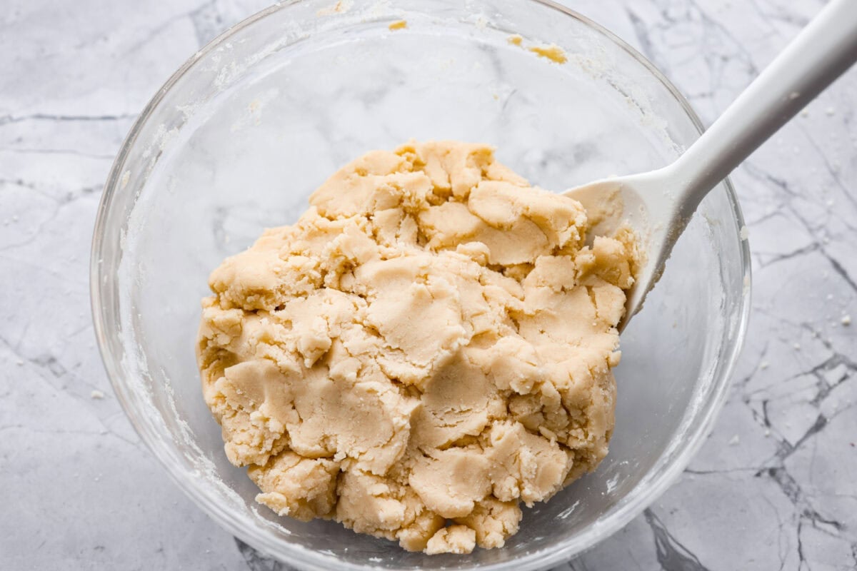 Simple to make and impossible to resist, these 4 ingredient sugar cookies are soft, tender, and sweet. A quick mix, a little roll, and your kitchen will smell like pure cookie heaven! Flour and extract added to the sugar and butter mixture.