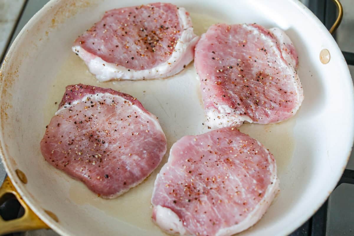 These honey mustard pork chops bring big flavor with very little effort. The whole grain mustard adds texture and bite, while a few extra spices deepen the sauce, turning a simple skillet dinner into something totally crave-worthy. Chops in a skillet with heated olive oil.