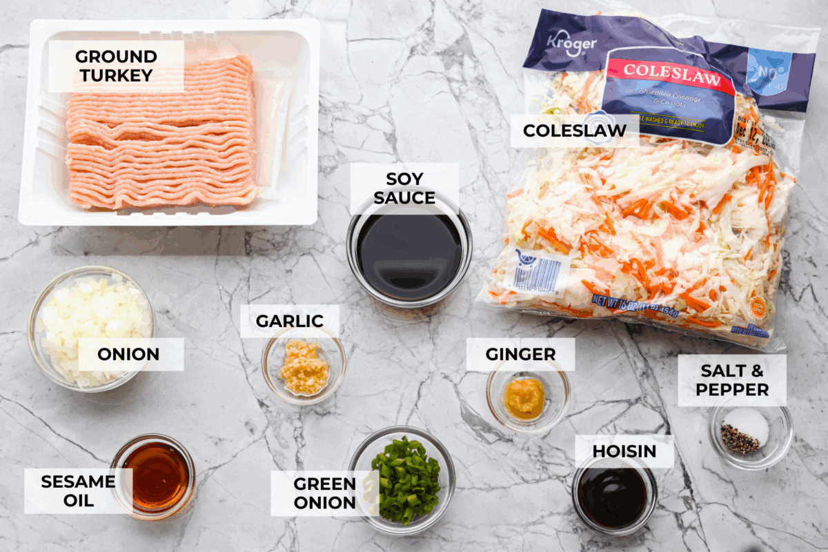 If you havenโt tried egg roll in a bowl yet, youโre in for a treat. Everything you love inside of an egg roll in a lighter, healthier, no-wrapper version! It's ready in 15 minutes, making it a perfect weeknight meal! Overhead shot of labeled egg roll in a bowl ingredients.