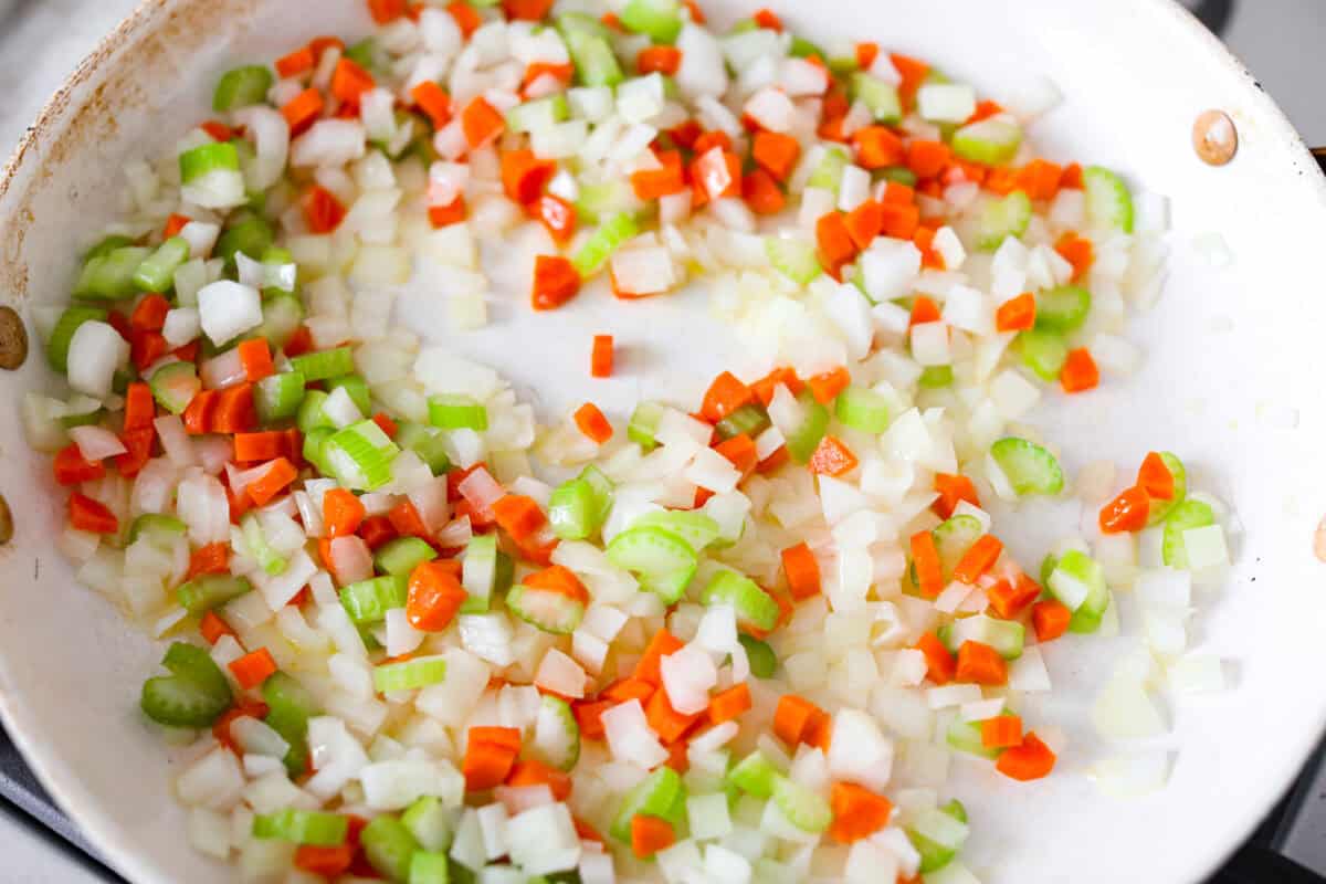 If you love my minestrone soup even a little, you have to try this minestrone casserole. It takes the cozy, veggie packed soup you already love and turns it into a hearty, cheesy pasta bake. It feels like weeknight dinner perfection. Carrots, onion, and celery cooking in a skillet.