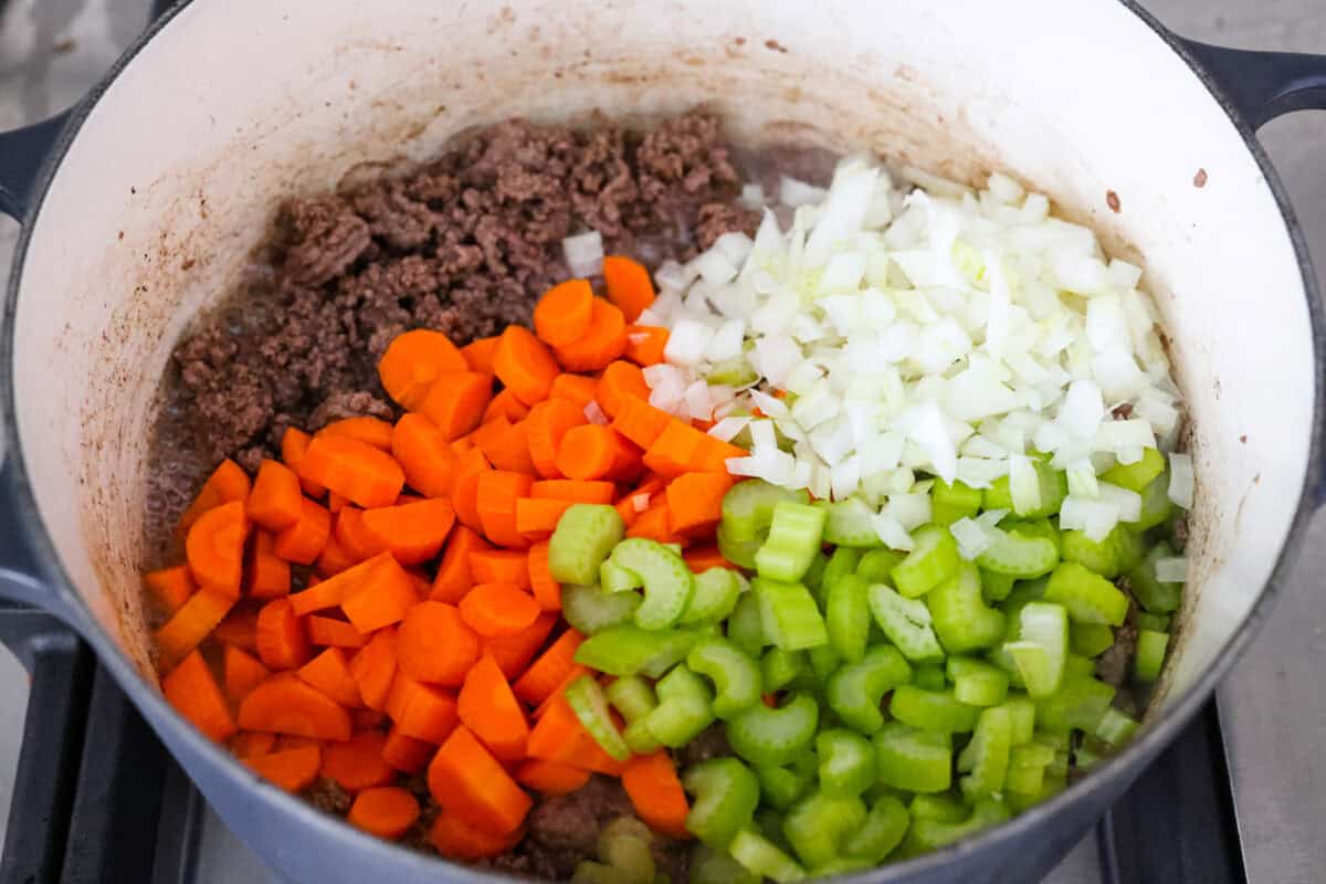 Shipwreck stew is a one-pot dinner that keeps things simple and affordable. Ground beef, tender potatoes, and everyday vegetables cook together in a rich tomato broth. It makes a cozy, filling meal without extra dishes or extra cost. Pot with cooked ground beef and onion, carrot, and celery.