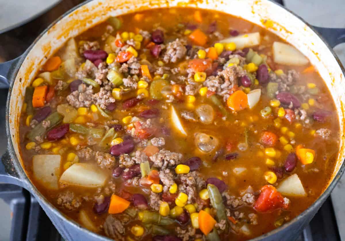 Shipwreck stew is a one-pot dinner that keeps things simple and affordable. Ground beef, tender potatoes, and everyday vegetables cook together in a rich tomato broth. It makes a cozy, filling meal without extra dishes or extra cost. Broth added to the pot of shipwreck stew.