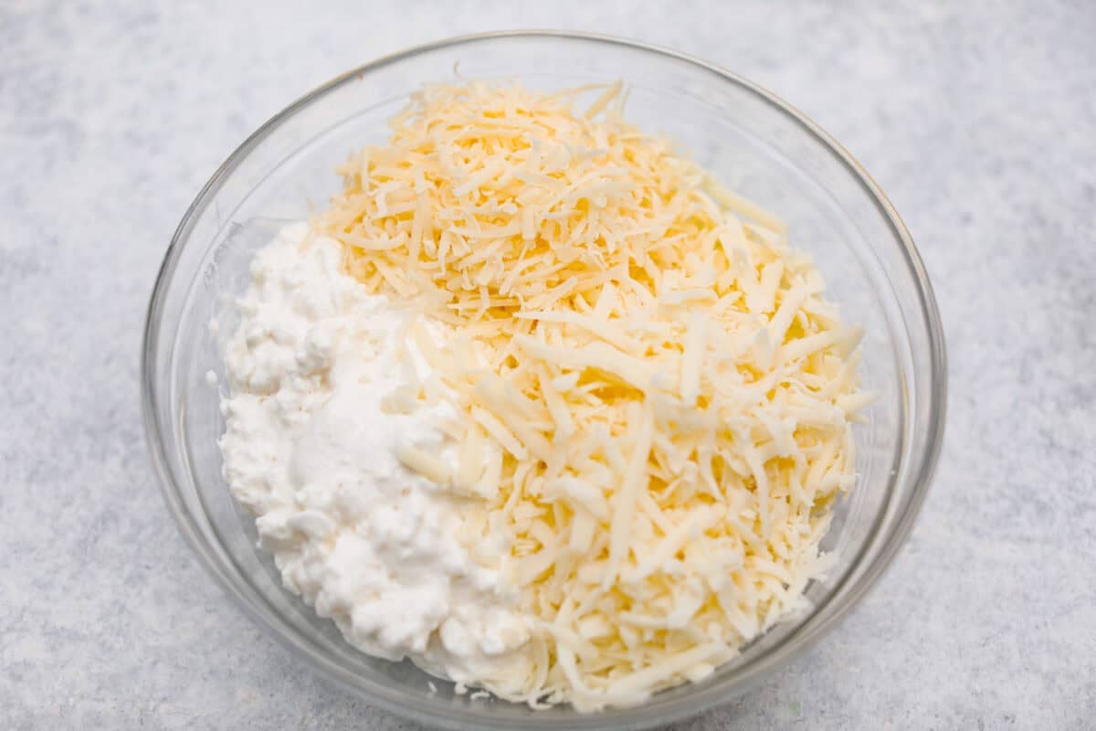 This easy slow cooker lasagna layers tender noodles with rich meat sauce and three cheeses, all with just 25 minutes of hands on prep. You get classic, cozy lasagna flavor that melds into every bite from slow cooking all day! All three cheeses mixed together in a bowl.