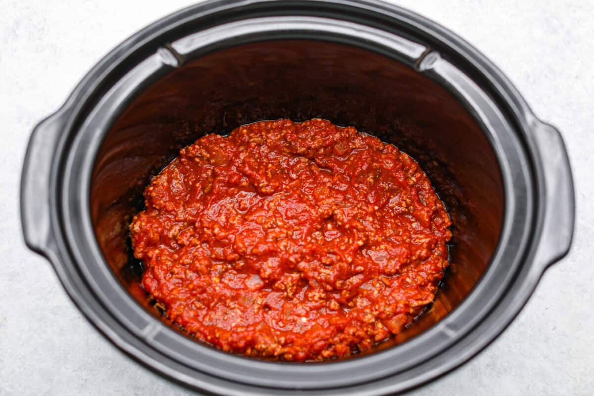 This easy slow cooker lasagna layers tender noodles with rich meat sauce and three cheeses, all with just 25 minutes of hands on prep. You get classic, cozy lasagna flavor that melds into every bite from slow cooking all day! Layer of meat sauce on the bottom of the slow cooker.