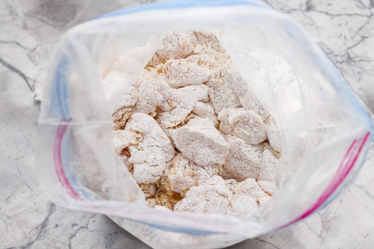 You love my baked General Tso’s chicken, so obviously, I had to make a faster one. This one pan General Tso's chicken is sticky, saucy, and on the table in about 30 minutes. Egg washed chicken in a ziplock bag covered in cornstarch.