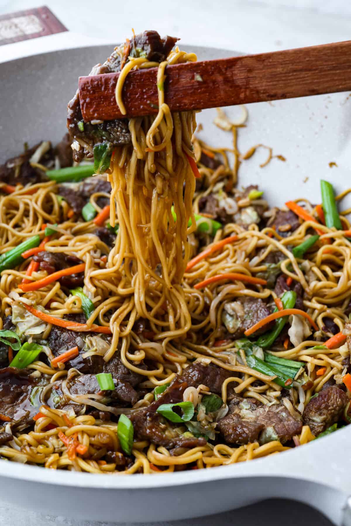 Skip the takeout, this Beef Chow Mein is ready in just 25 minutes! Packed with tender beef, crisp veggies, and saucy noodles, it’s a fast, flavorful dinner that hits the spot every time. Side shot of someone pulling up a scoop of beef chow mein from the skillet.
