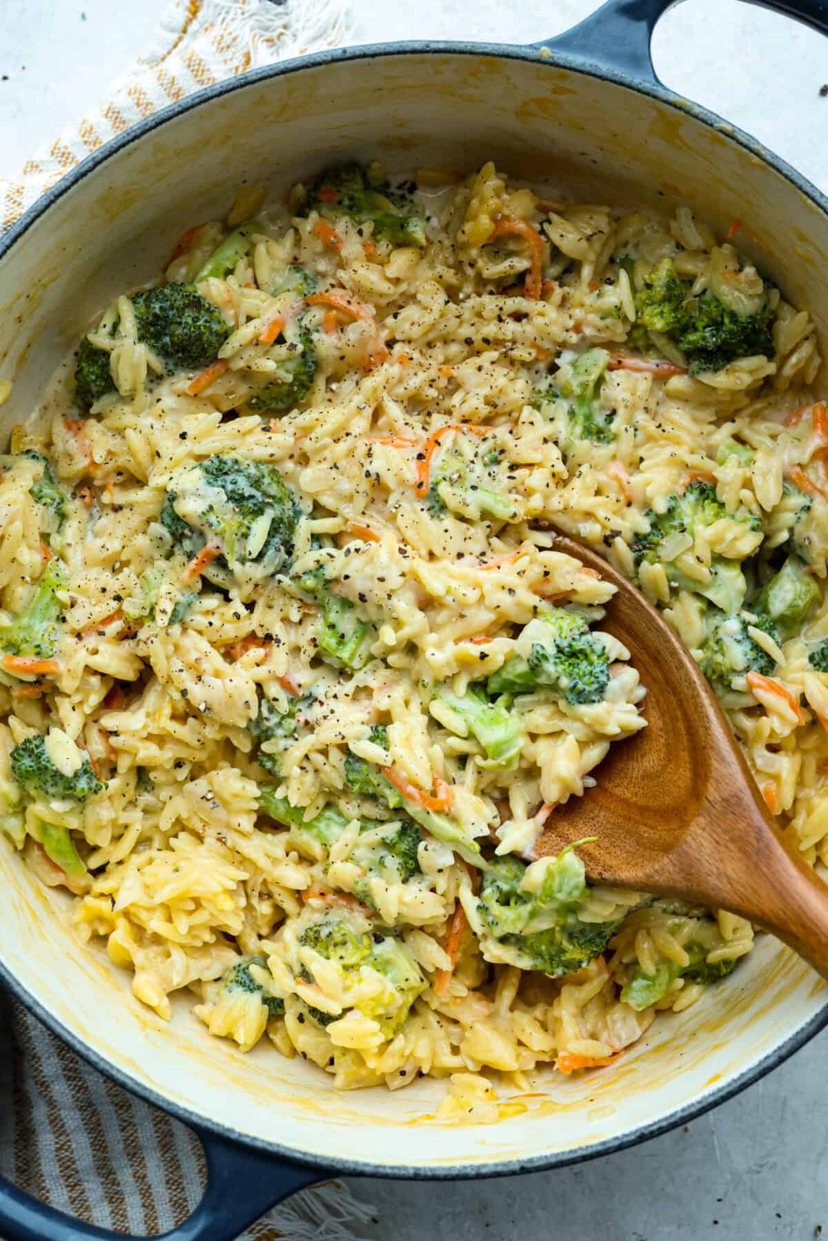 You guys are obsessed with my Broccoli Cheddar soup, and I know you love a good orzo recipe. So this simple, one-pot, ready-in-30-minute Broccoli Cheddar Orzo was born! Broccoli Cheddar Orzo in a large skillet.