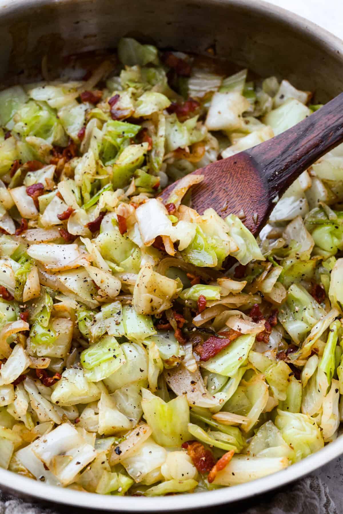 You donโt need fancy ingredients to make something great, and this fried cabbage proves that! Bacon, cabbage, a little seasoning, and a hot skillet. Thatโs it. And it works every single time. Close up shot of fried cabbage cooked and ready to serve.