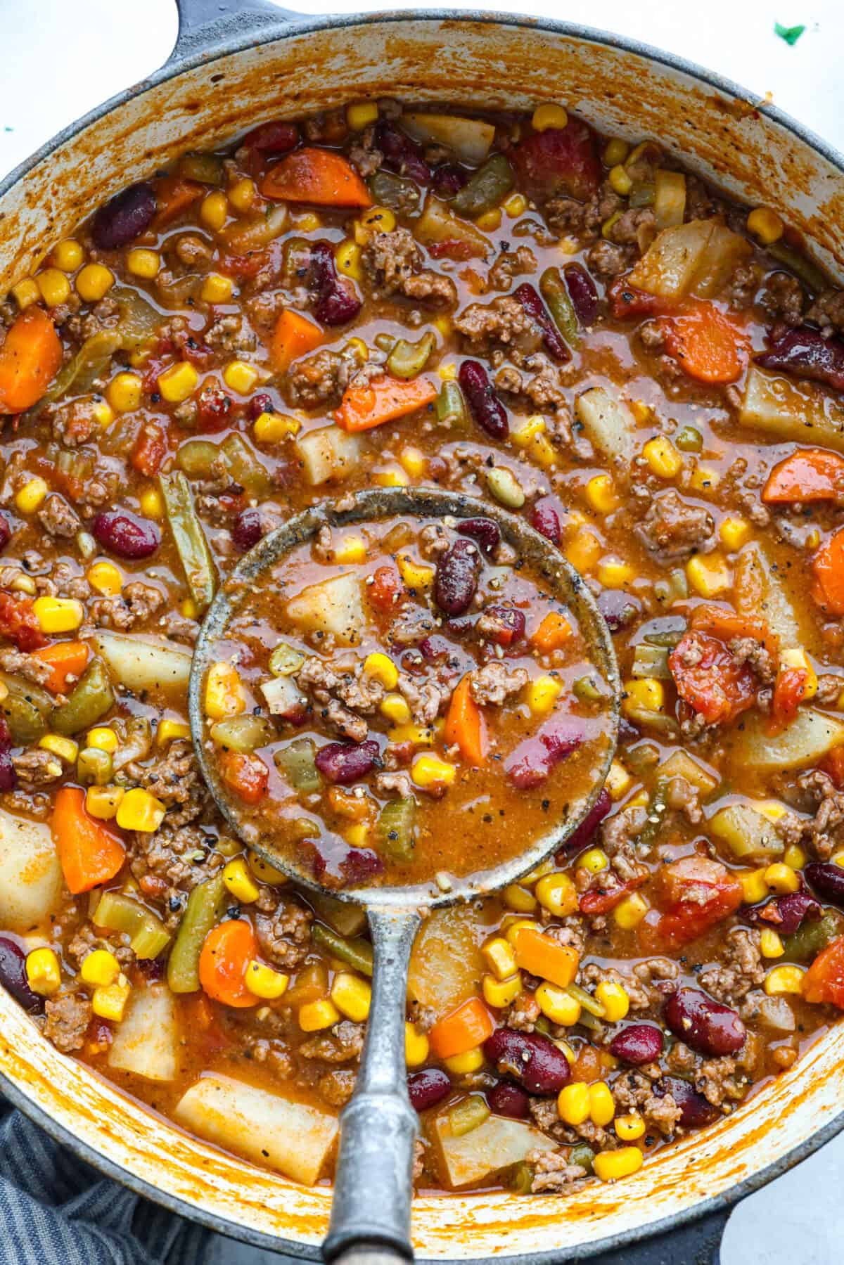 Shipwreck stew is a one-pot dinner that keeps things simple and affordable. Ground beef, tender potatoes, and everyday vegetables cook together in a rich tomato broth. It makes a cozy, filling meal without extra dishes or extra cost. Pot of shipwreck stew with a ladle in it.