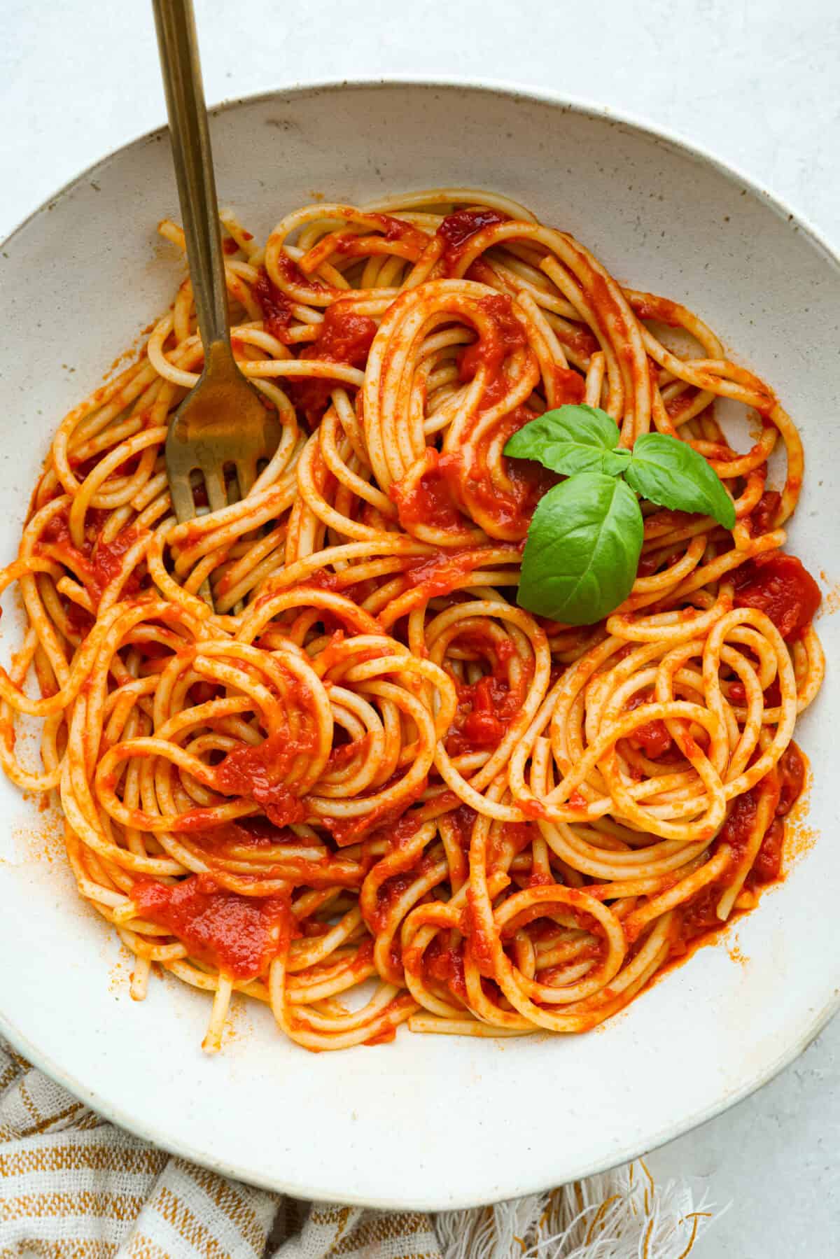 Simple, classic, and downright magical, this iconic Marcella Hazan's tomato sauce uses only 3 ingredients and proves that less is more. With just tomatoes, butter, and onion, it turns pantry staples into a rich, silky sauce you’ll make on repeat. Plate of pasta covered in Marcella Hazan's tomato sauce.