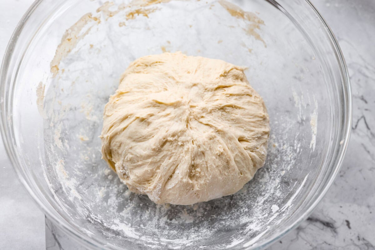 Myย 4-ingredient artisan breadย is simple, rustic, and completely bakery-worthy. With just flour, water, yeast, and salt, youโll get a loaf with a crusty outside and a soft, chewy center. Overhead shot of the dough ball all stretched and folded over back into a ball.