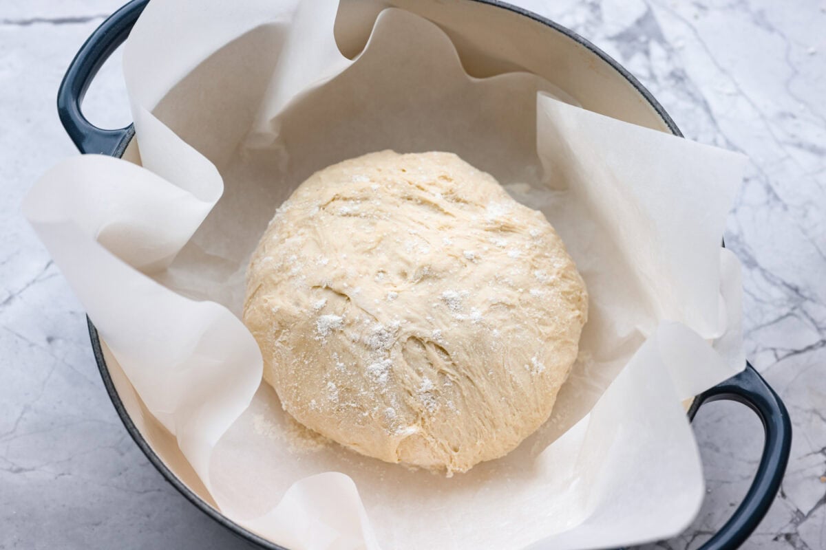 Myย 4-ingredient artisan breadย is simple, rustic, and completely bakery-worthy. With just flour, water, yeast, and salt, youโll get a loaf with a crusty outside and a soft, chewy center. Ball of dough floured and placed in a dutch oven with parchment paper.