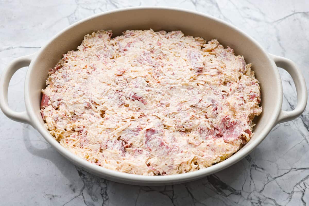 Think of this hot Reuben dip as a love letter to the classic Reuben sandwich. Itโs rich, tangy, loaded with corned beef and sauerkraut, and the perfect way to turn St. Patrickโs Day leftovers into something everyone fights over. All of the dip ingredients added to a baking dish.
