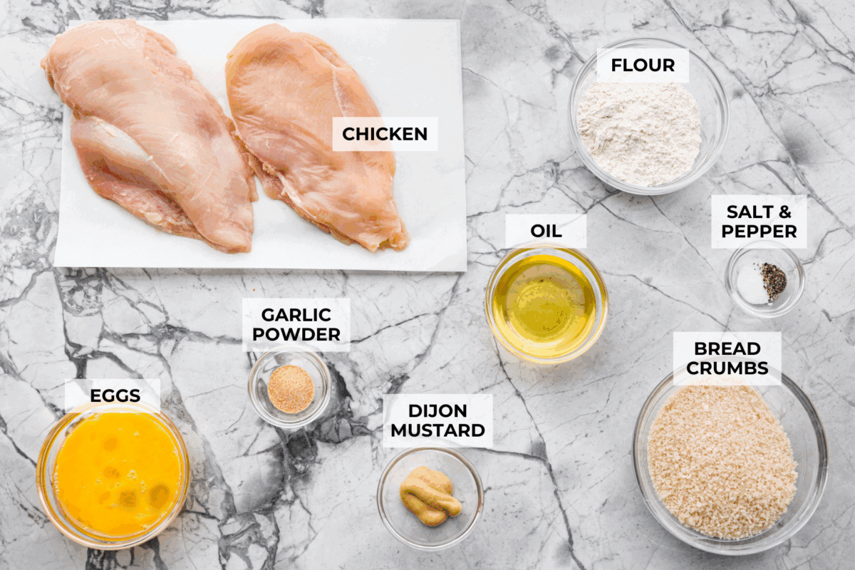 Chicken schnitzel will win you over at first crunch! Thin-pounded, perfectly seasoned chicken is fried to a golden crisp. It’s a timeless, flavor-packed dish that will have your whole family coming back for seconds. Overhead shot of labeled chicken schnitzel ingredients.
