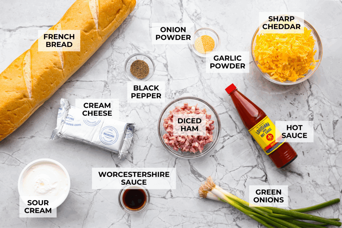 This Mississippi sin dip is pure comfort-food goodness. Creamy, cheesy, a little smoky, and baked into a loaf of French bread, itโs the kind of snack everyone gathers around and keeps going back for! Overhead shot of labeled Mississippi sin dip ingredients.