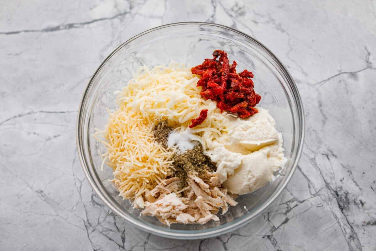 Marry me stuffed shellsย take the viral sauce you love and turn it into a cozy, baked pasta moment. Think creamy chicken-stuffed shells, melty cheese, and just enough sun-dried tomatoes for that extra swoon-worthy touch. Filling ingredients added to a bowl.