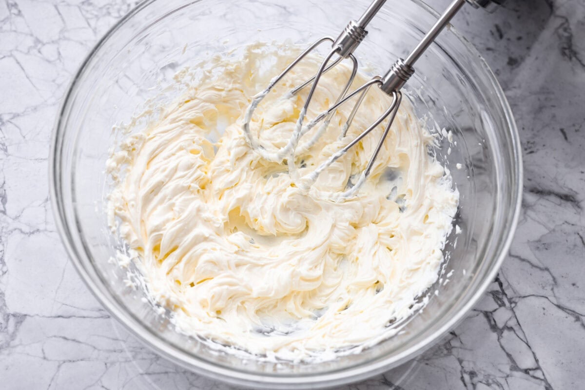 This Mississippi sin dip is pure comfort-food goodness. Creamy, cheesy, a little smoky, and baked into a loaf of French bread, itโs the kind of snack everyone gathers around and keeps going back for! Someone using a had mixer to beat the cream cheese.