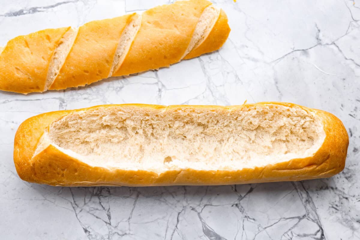 This Mississippi sin dip is pure comfort-food goodness. Creamy, cheesy, a little smoky, and baked into a loaf of French bread, itโs the kind of snack everyone gathers around and keeps going back for! Loaf of french bread cut in half the long way and the bread pulled out of the middle.
