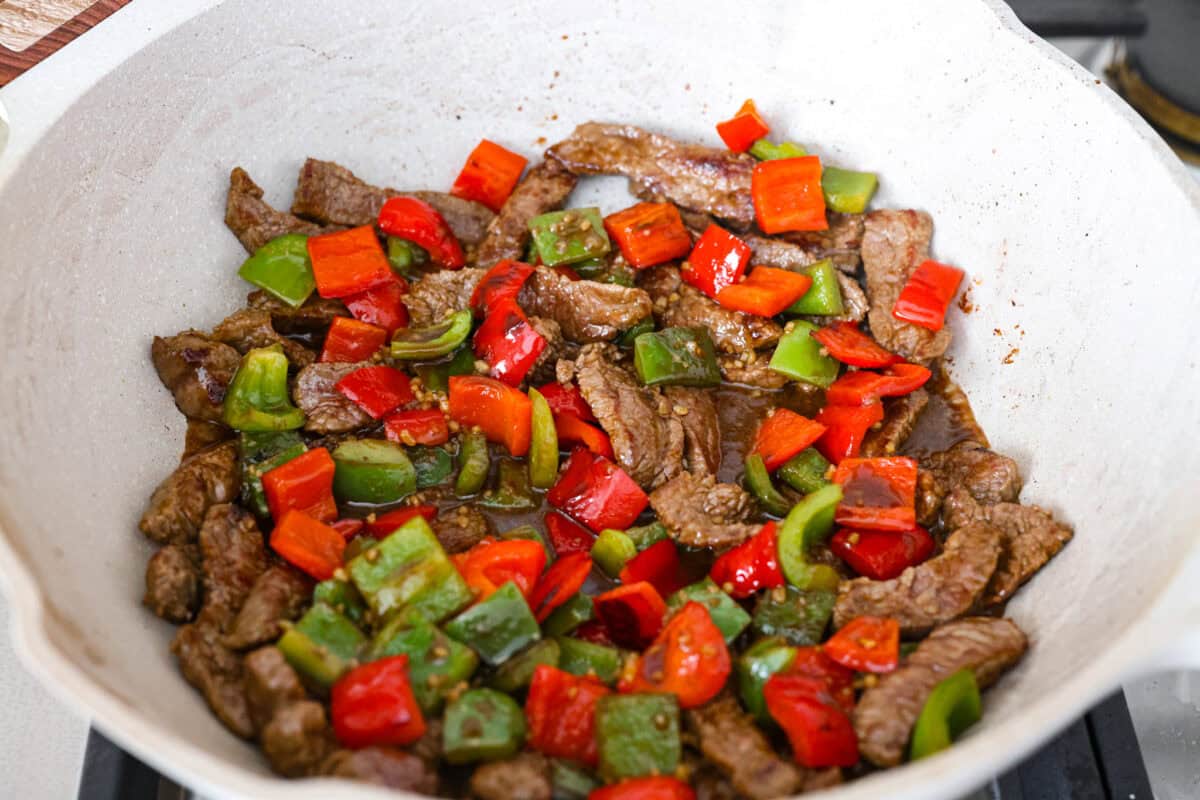 Trust me on this one. If you want the most tender pepper steak you’ve ever made at home, this recipe is it. It’s fast, saucy, and I give you just enough tips to make it work on a busy night! Steak, peppers, and sauce all cooking in a wok.