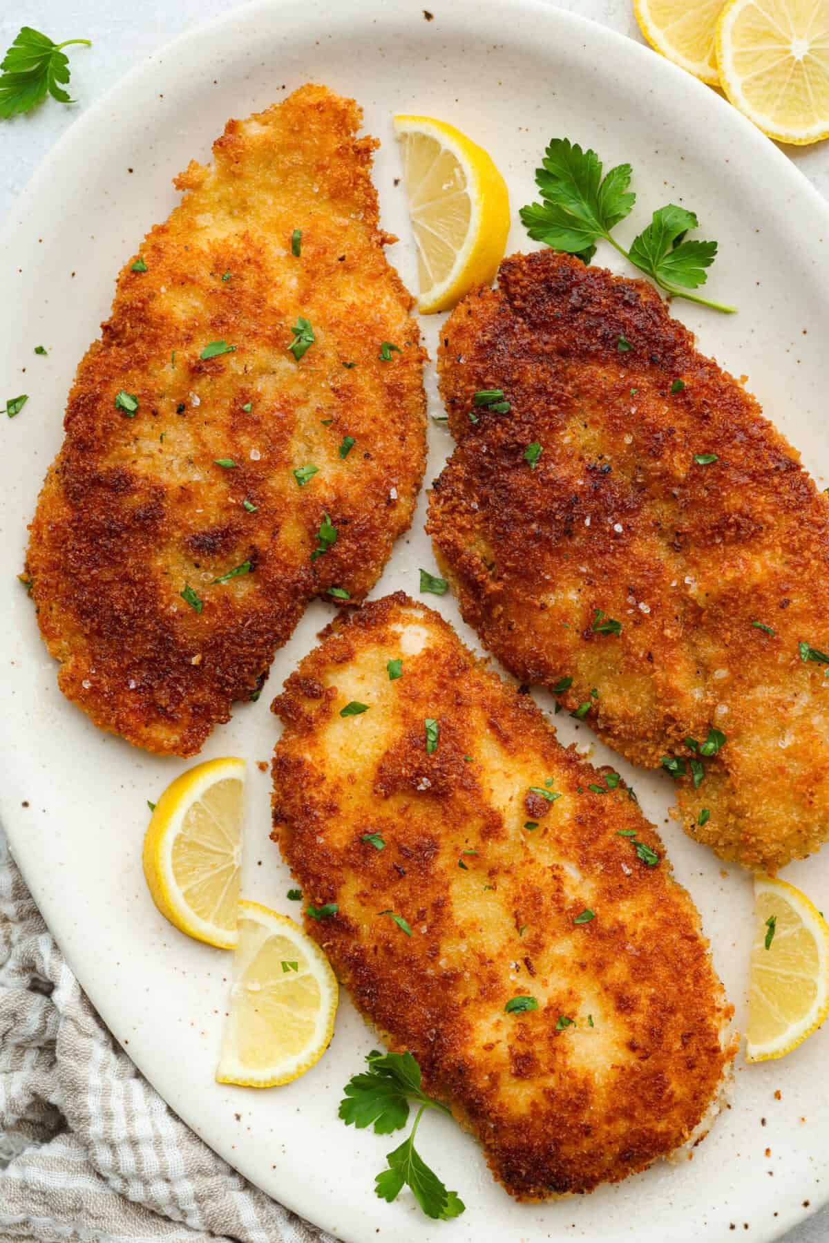 Chicken schnitzel will win you over at first crunch! Thin-pounded, perfectly seasoned chicken is fried to a golden crisp. It’s a timeless, flavor-packed dish that will have your whole family coming back for seconds. Platter with chicken schnitzel on it.