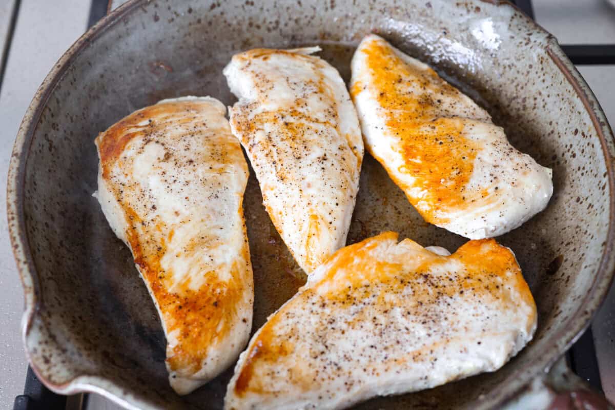I'm excited for you guys to try this cream cheese chicken. It's an easy one-pan dinner with a rich, creamy sauce that delivers pure comfort food vibes. Itโs quick to make, easy to clean up, and perfect for cozying up on a busy night. Chicken cooking in a skillet.