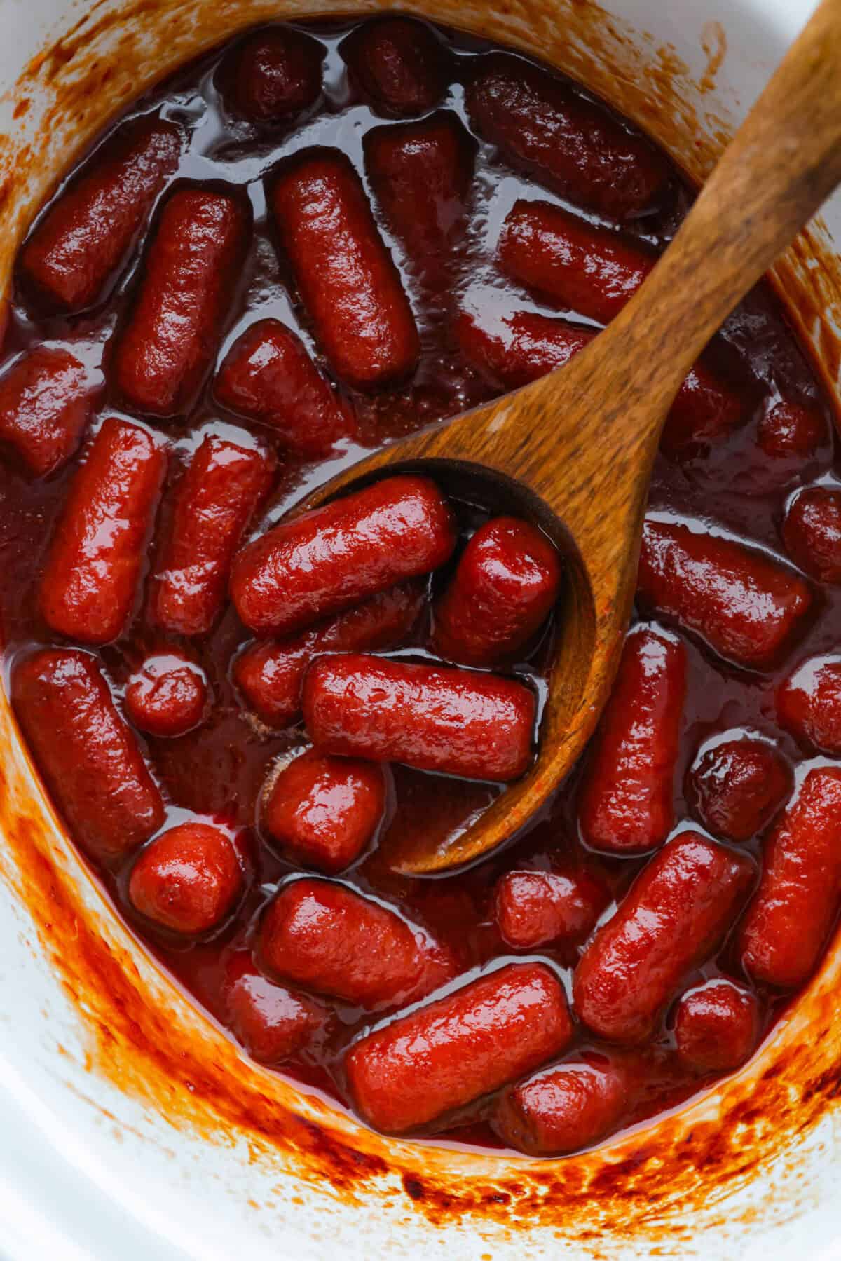 If youโre hosting anything and need a quick appetizer, these crockpot grape jelly little smokies are it. Dump everything in the slow cooker, walk away, and come back to glossy, flavorful sausages that people hover around all night. Crockpot grape jelly little smokies in a slow cooker with a large wooden spoon.