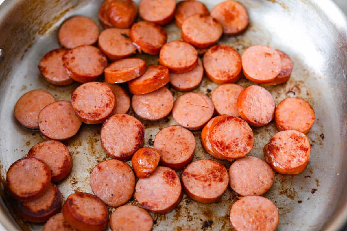 This Cajun spaghetti is comforting like classic spaghetti but delivers a bold Cajun kick with sausage and a creamy sauce. You'll have a super flavorful dinner your whole family will love in no time! Sausage browning in a pan.