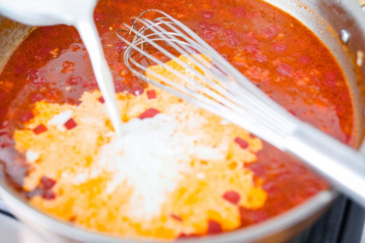 This Cajun spaghetti is comforting like classic spaghetti but delivers a bold Cajun kick with sausage and a creamy sauce. You'll have a super flavorful dinner your whole family will love in no time! Someone whisking in the heavy cream.