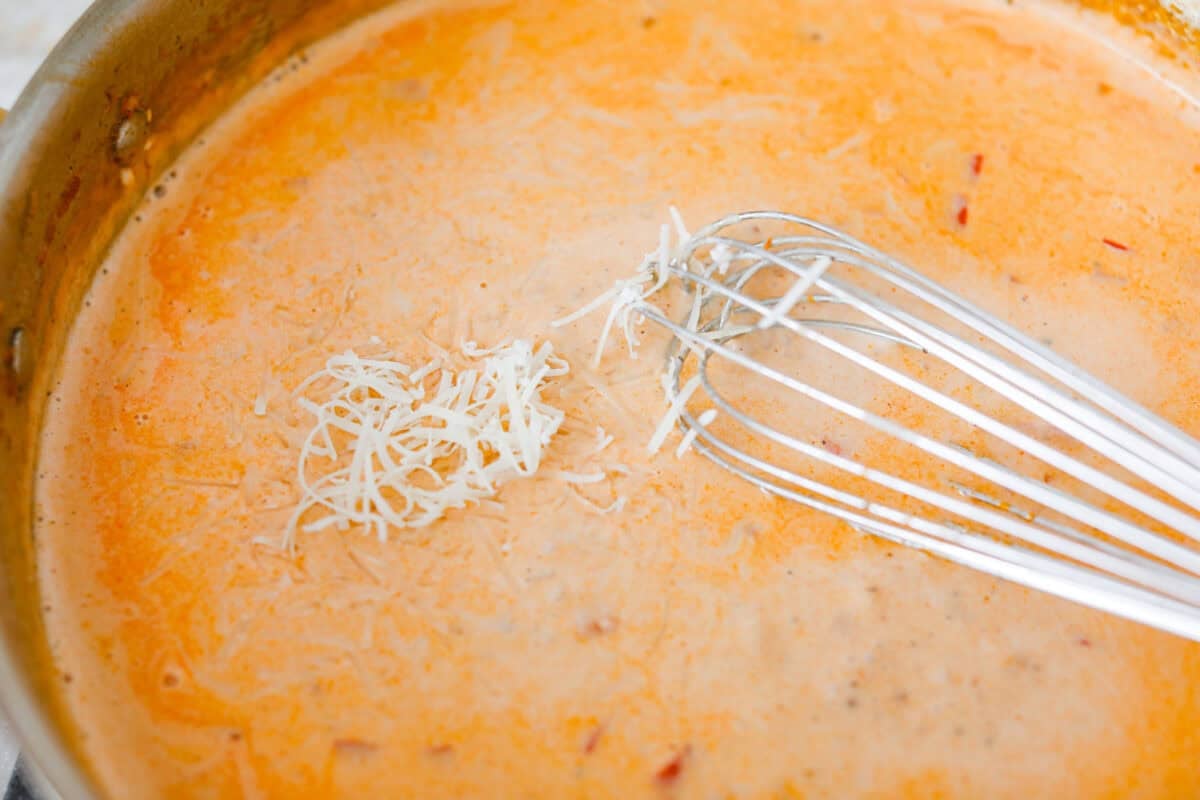This Cajun spaghetti is comforting like classic spaghetti but delivers a bold Cajun kick with sausage and a creamy sauce. You'll have a super flavorful dinner your whole family will love in no time! Someone whisking in the cheese