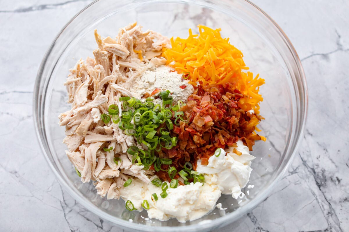 Get ready to be instantly obsessed with these crack chicken tacos! They are loaded with creamy ranch chicken, crispy bacon, and melty cheddar for a can’t-stop-eating dinner that disappears fast. crack chicken ingredients all added to a mixing bowl.
