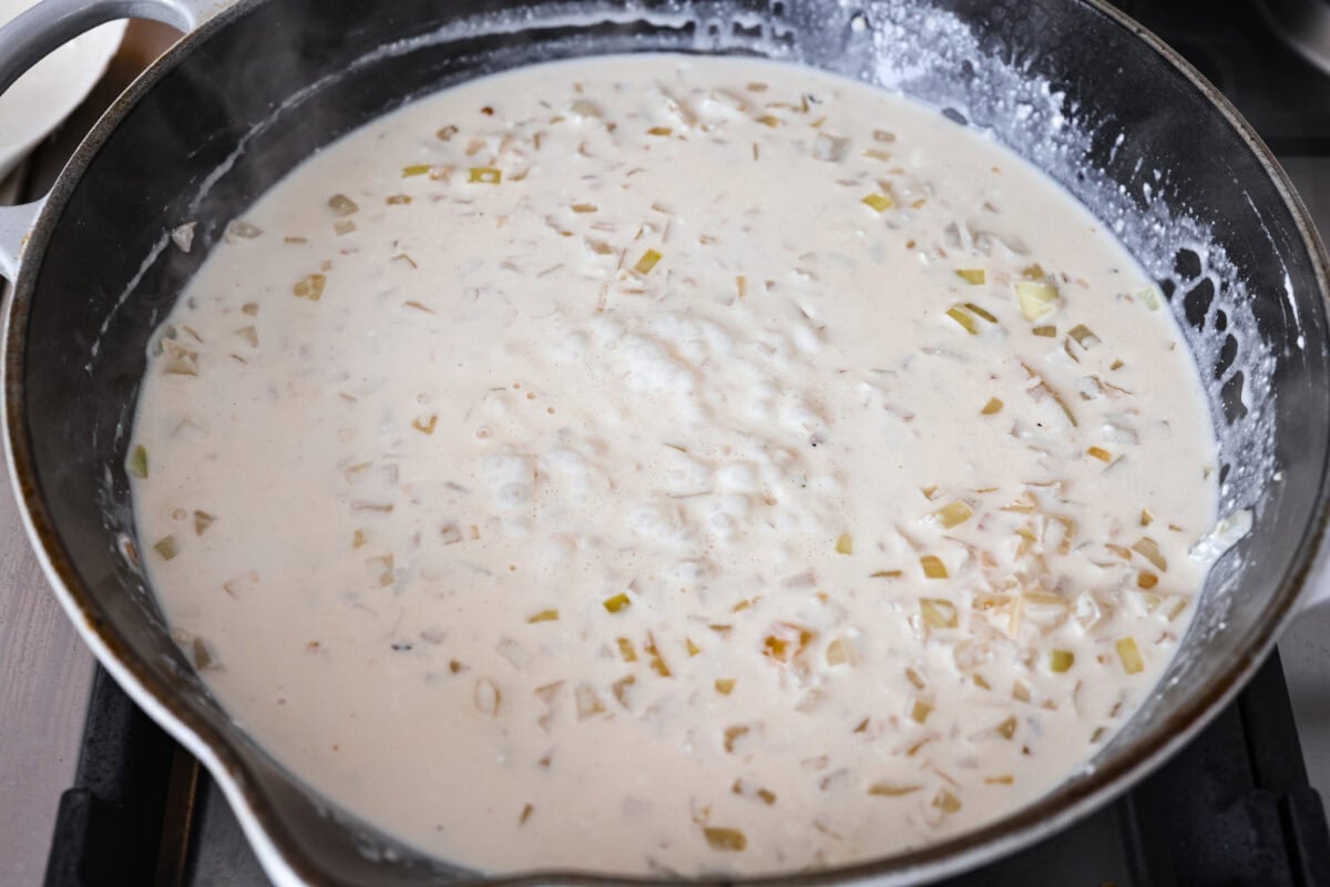 Groceries are expensive right now, so Iโve been leaning hard on the cheap staples. This melting cabbage with a garlicky cream sauce, sun-dried tomatoes, and Parmesan is easy, budget friendly, and tastes amazing. Broth added to the pan and cream cheese added to that and melted to start the sauce.