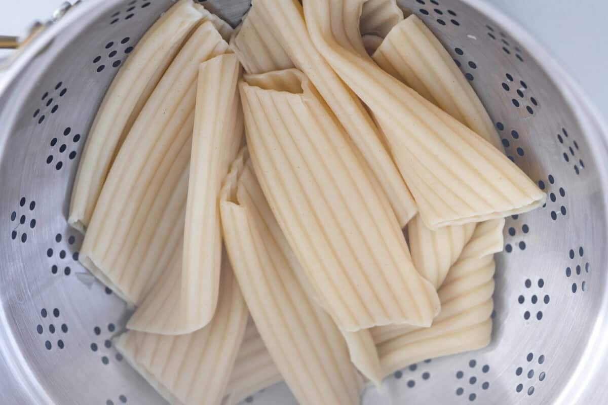 My classic manicotti is a reader favorite, so I wanted to make a version with a little more protein. Sausage is one of my favorite pasta add-ins, and it keeps this new Sausage Manicotti budget-friendly, hearty, cheesy, and so satisfying. Manicotti pasta noodles cooked and in a colander.
