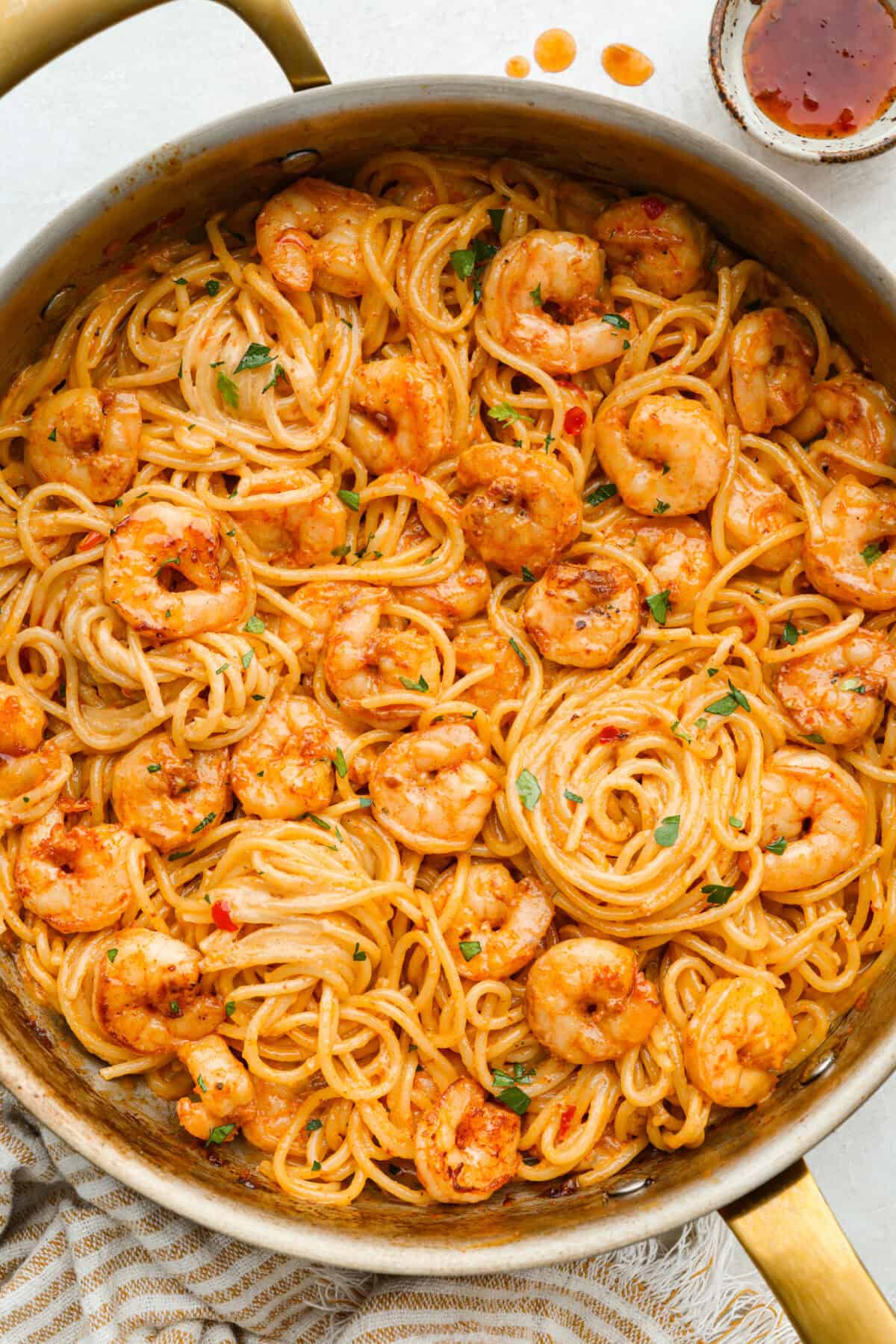 Bang bang shrimp pasta is what weeknight dinner dreams are made of! Juicy shrimp, tender pasta, and that irresistible sweet-and-spicy bang bang sauce come together in just 20 minutes. It’s creamy, bold, and guaranteed to be a hit. Skillet of bang bang shrimp pasta.