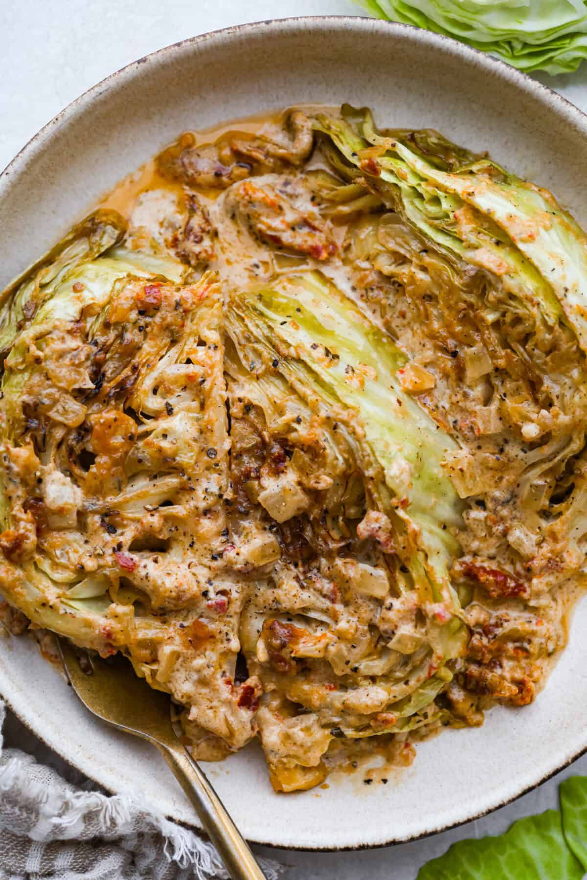 Groceries are expensive right now, so Iโve been leaning hard on the cheap staples. This melting cabbage with a garlicky cream sauce, sun-dried tomatoes, and Parmesan is easy, budget friendly, and tastes amazing. Plated tuscan melting cabbage ready to be eaten.