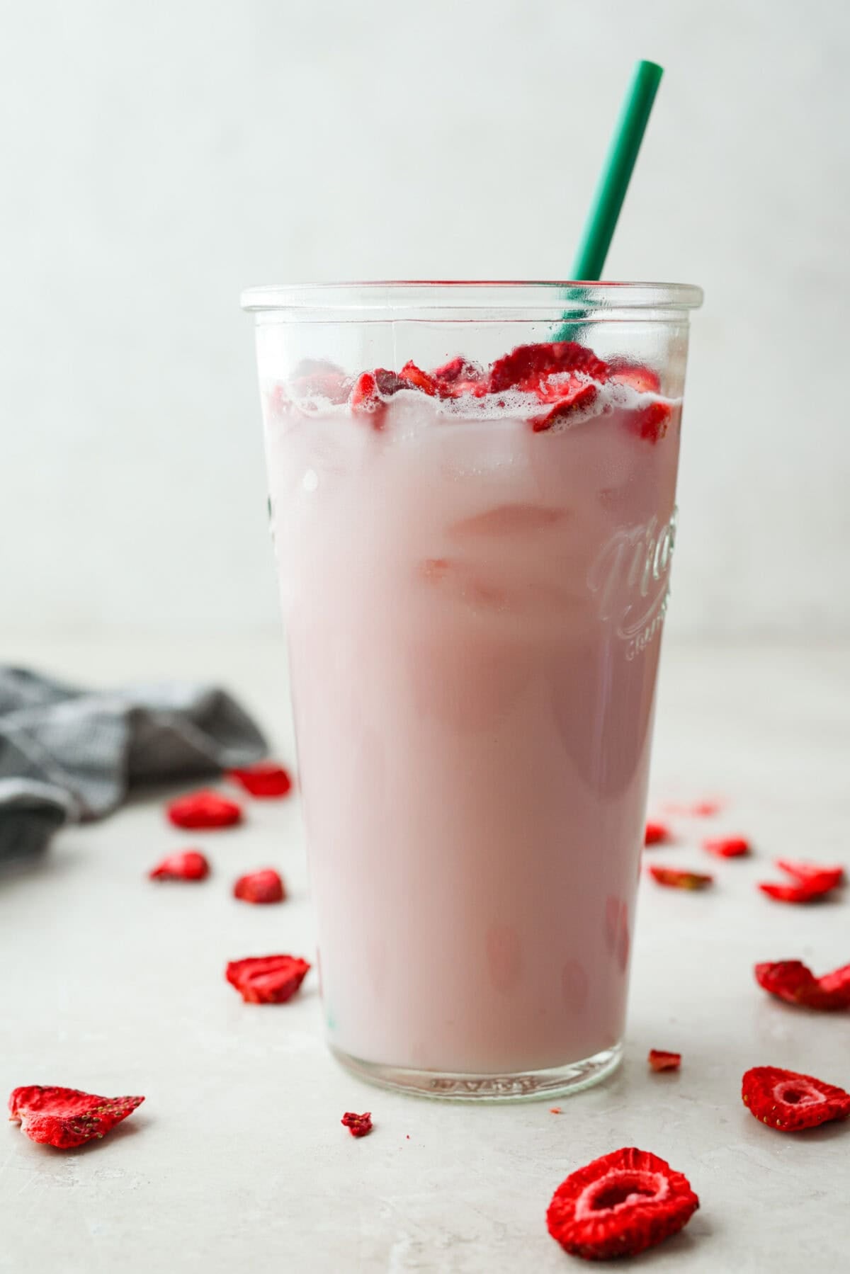 You guys, Starbucks sells the Strawberry Aรงaรญ concentrate in stores! Which means we can make the famous Starbuck's Pink Drink at home! And let me tell you, it's spot on! With just three ingredients, it's ridiculously easy to make year-round, and so good! Large glass with Starbucks copycat pink drink and green straw.
