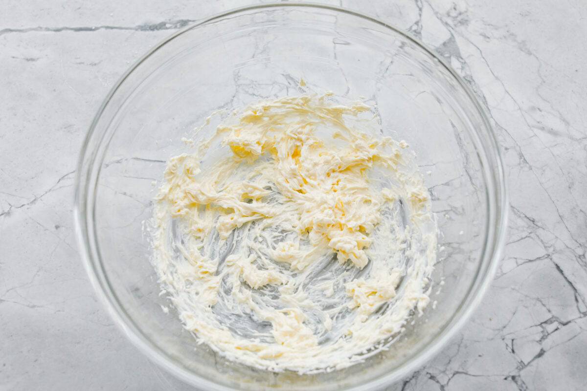 These cinnamon roll butter swim biscuits are my cheat code to making "cinnamon rolls." They bake up soft and fluffy with a sweet cinnamon swirl and icing on top. They disappear almost as fast as you can make them! Cream cheese mixed in a bowl for the icing.