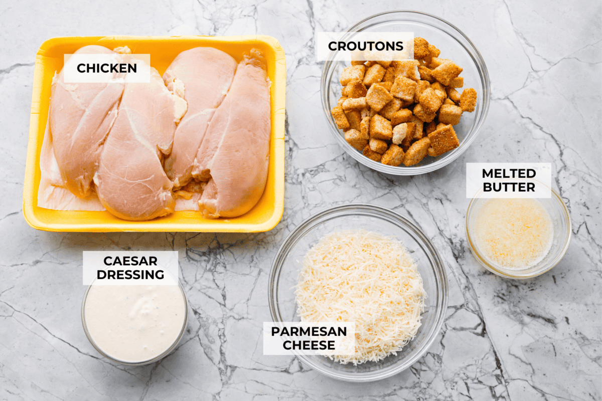 My Caesar chicken bakeย turns classic Caesar salad flavors into an easy one-pan dinner! Juicy chicken is smothered in creamy dressing, topped with parmesan and buttery crushed croutons, and baked to golden, cheesy perfection. Overhead shot of labeled ingredients.