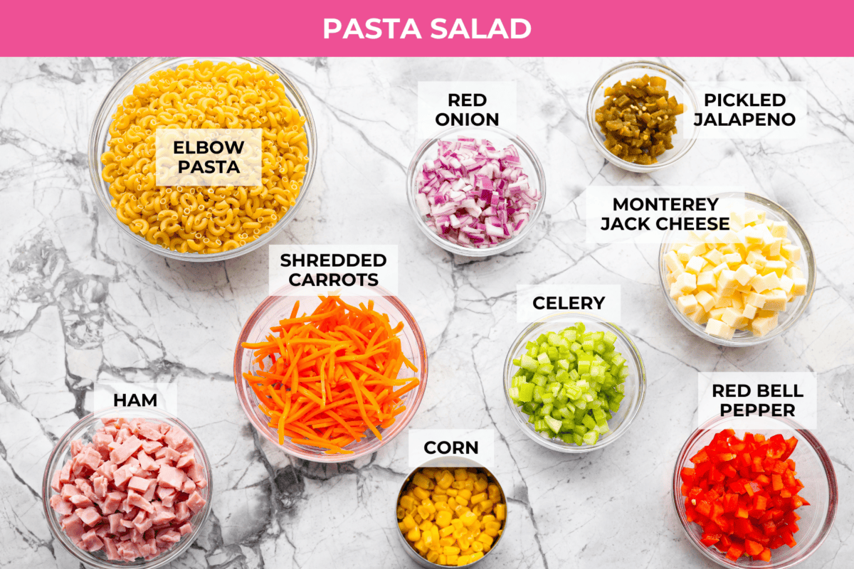 This Mexican macaroni salad is a fun twist on a classic! Itโs creamy, tangy, and full of flavor with crisp veggies, cheese, and a little kick from jalapeรฑos. Perfect for BBQs, potlucks, or anytime you want an easy, delicious side. Overhead shot of labeled pasta salad ingredients.