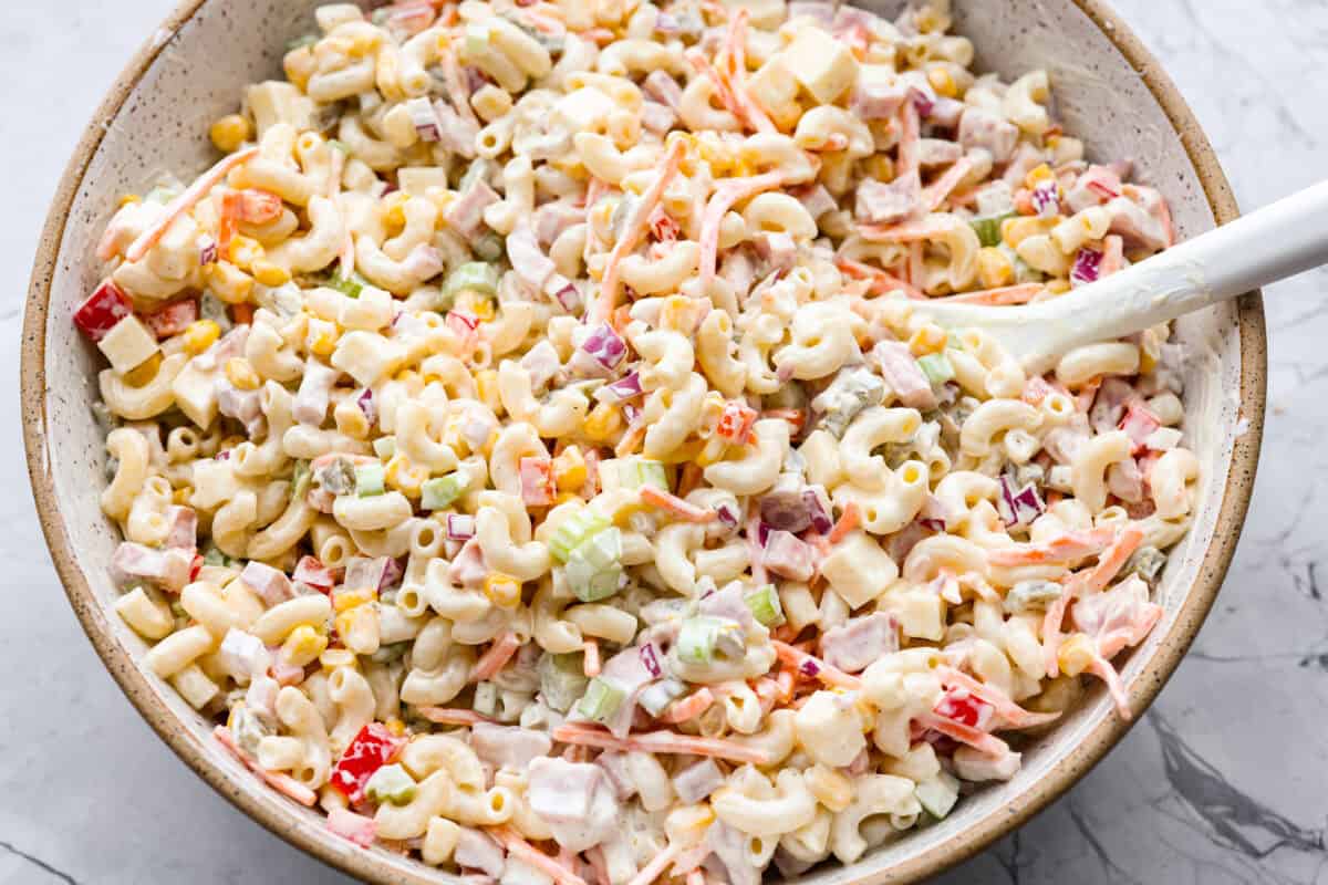 This Mexican macaroni salad is a fun twist on a classic! Itโs creamy, tangy, and full of flavor with crisp veggies, cheese, and a little kick from jalapeรฑos. Perfect for BBQs, potlucks, or anytime you want an easy, delicious side. Mexican macaroni salad ingredients all mixed together with the dressing.