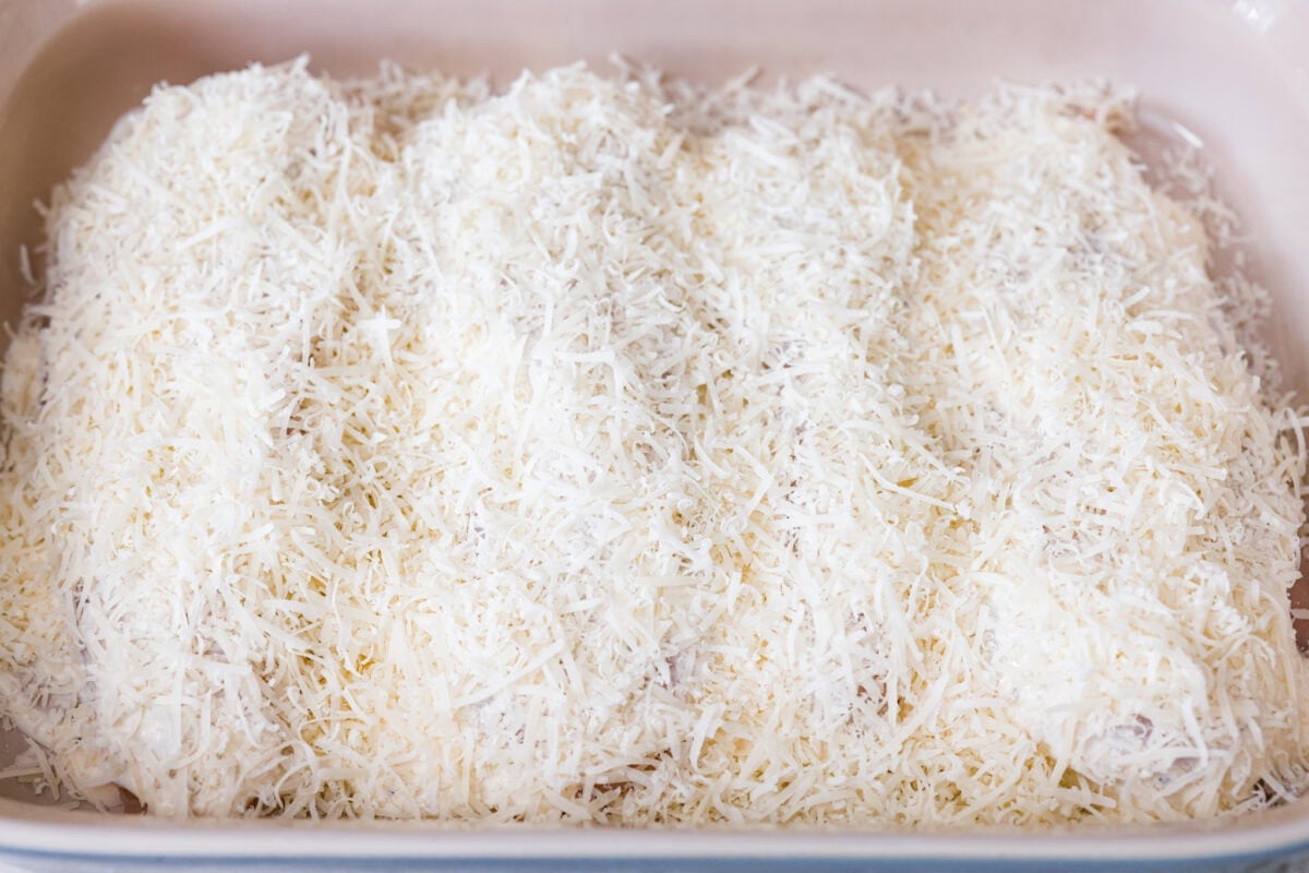 My Caesar chicken bakeย turns classic Caesar salad flavors into an easy one-pan dinner! Juicy chicken is smothered in creamy dressing, topped with parmesan and buttery crushed croutons, and baked to golden, cheesy perfection. Parmesan cheese covering the tops of the caesar dressing covered chicken breasts.