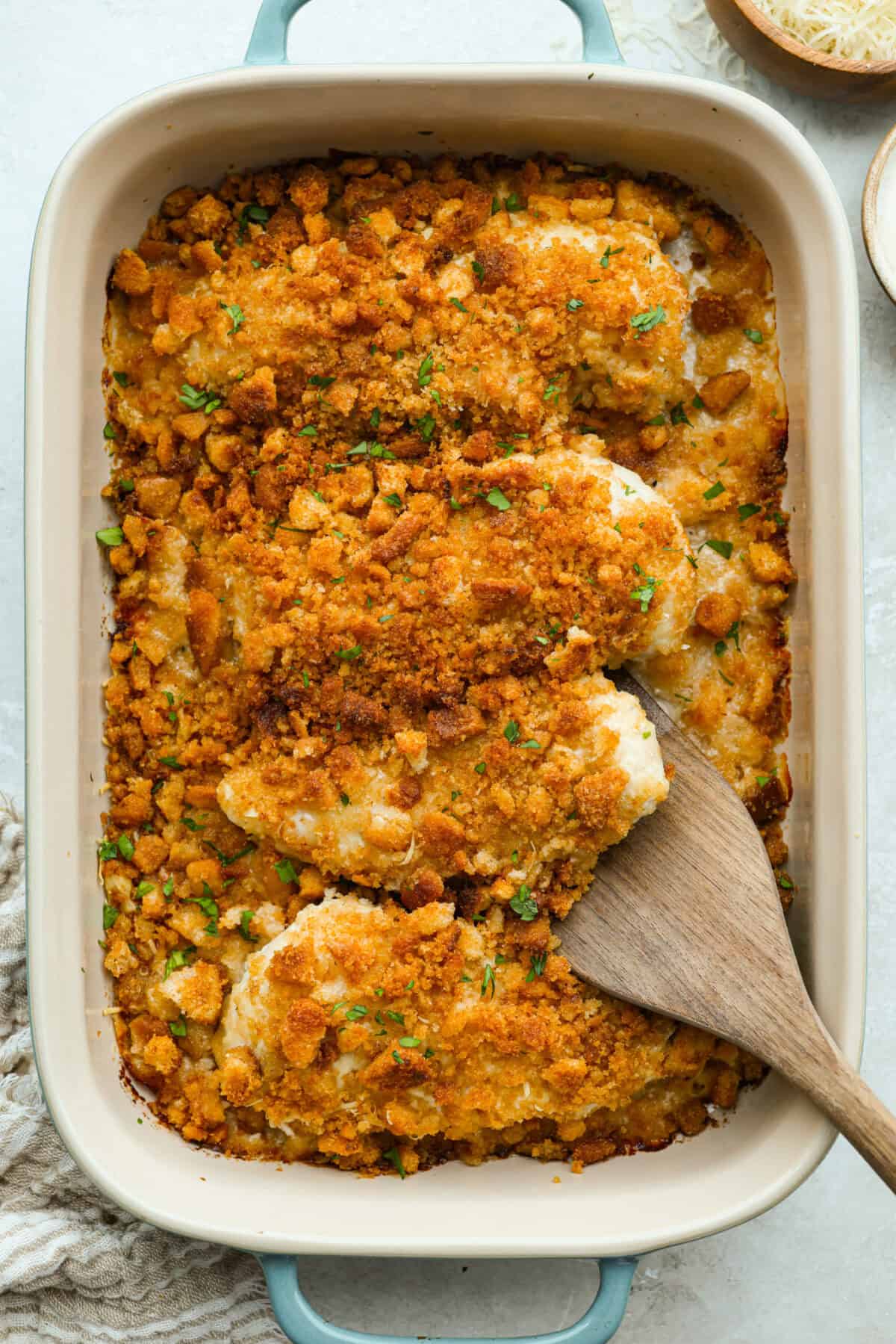 My Caesar chicken bakeย turns classic Caesar salad flavors into an easy one-pan dinner! Juicy chicken is smothered in creamy dressing, topped with parmesan and buttery crushed croutons, and baked to golden, cheesy perfection. Overhead shot of baked to perfection Caesar Chicken Bake in a baking dish.
