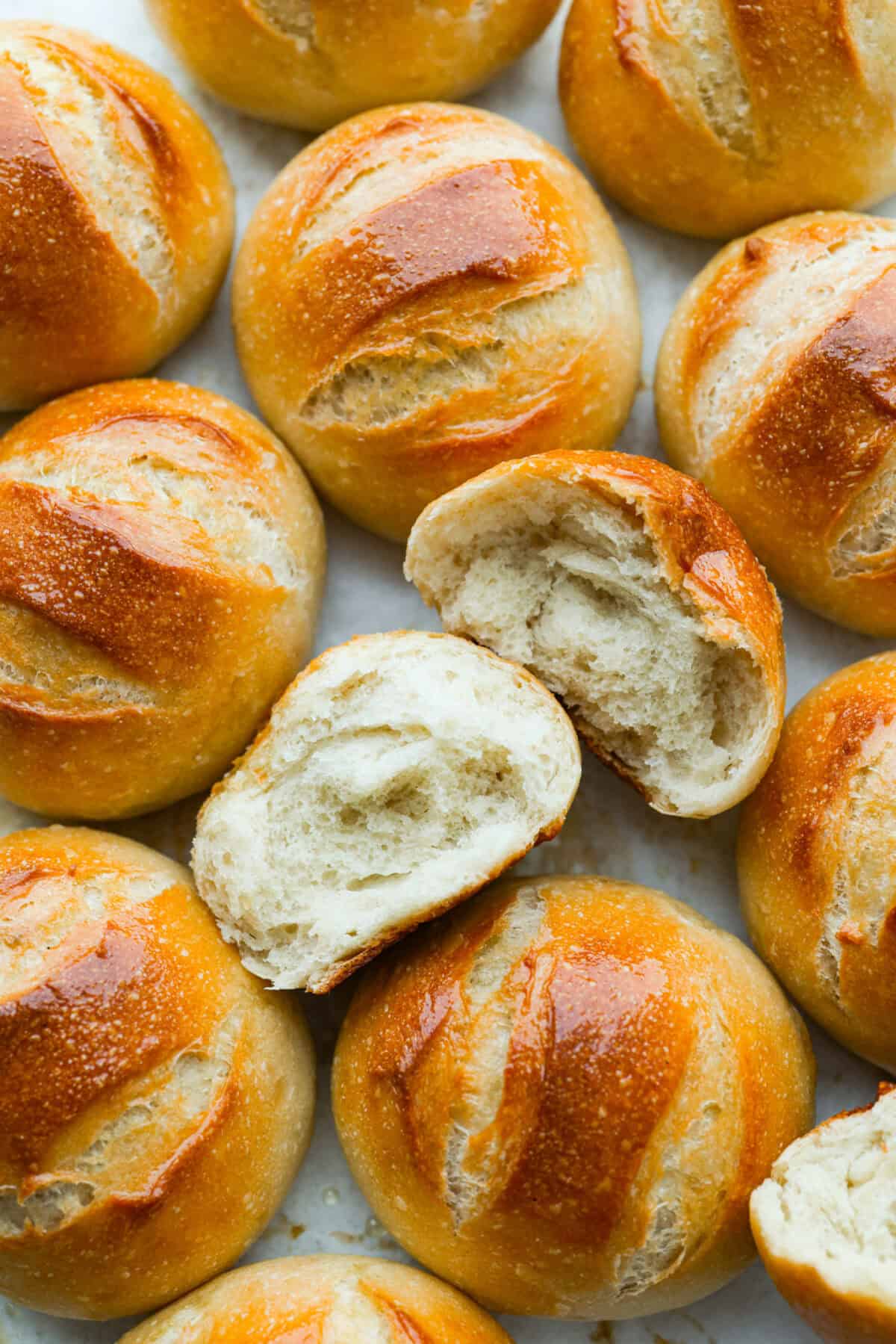 If warm, homemade bread is your weakness, youโre going to love these French bread rolls. Theyโre soft, chewy, and perfect for everything from weeknight dinners to holiday meals. French bread rolls all on a surface with one split in half so we can see the soft center and crunchy outside.