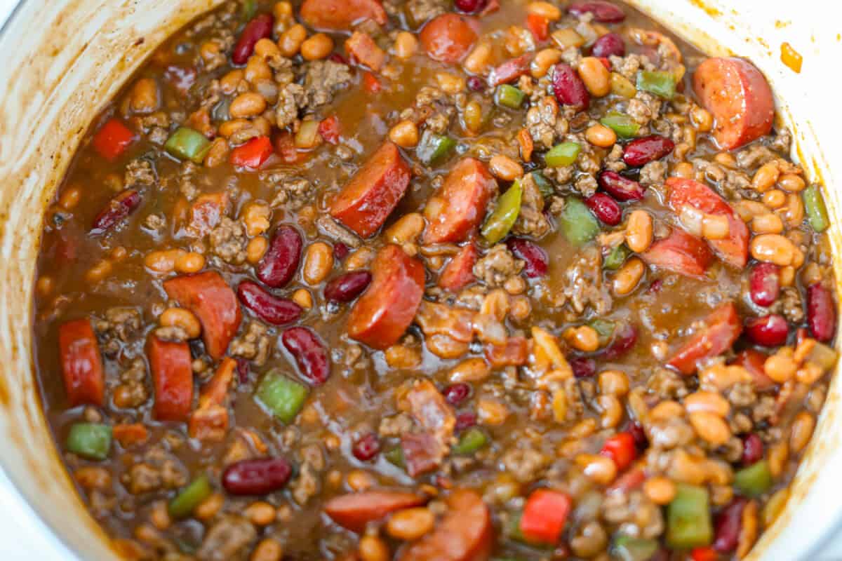 If you're bringing a dish to the cookout, make it these loaded baked beans. Three kinds of meat, two kinds of beans, and a sauce that is smoky, sweet, and full of depth. They disappear every single time. Everything added to the pot and stirred together, ready to go in the oven.